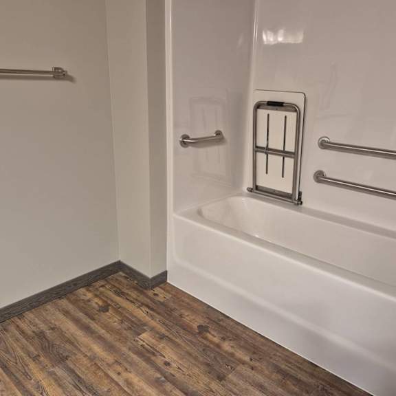 a white bathtub with a shower head and hand held shower.