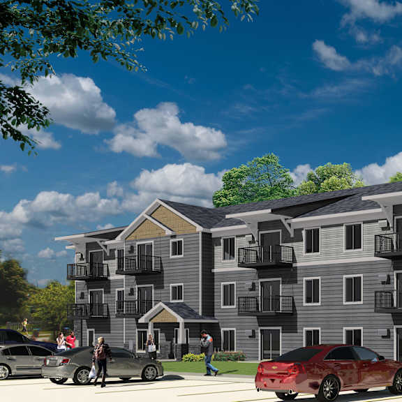 a red car is parked in front of a grey apartment building.