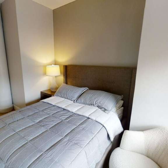 a white bed in a room with geometric wallpaper