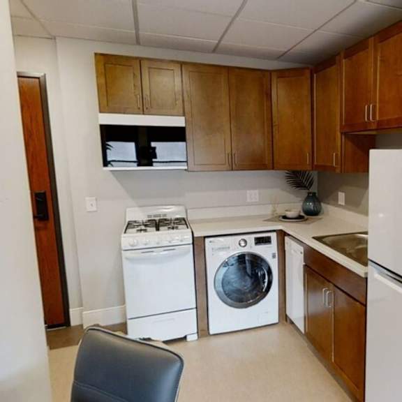 a kitchen with white appliances and wooden cabinets