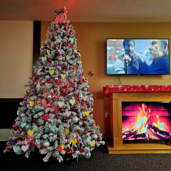 a christmas tree in a living room with a fireplace