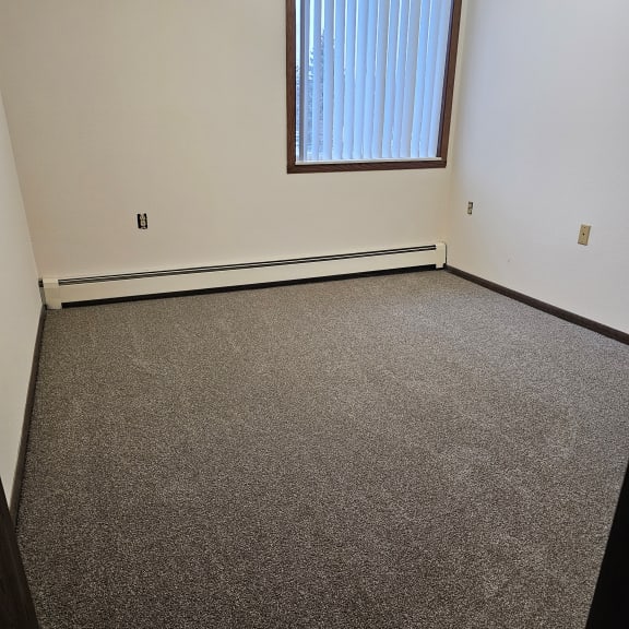 a room with a carpeted floor and a window