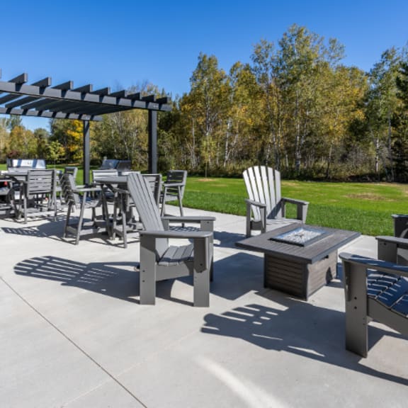 a patio with a table, chairs and a pergola.