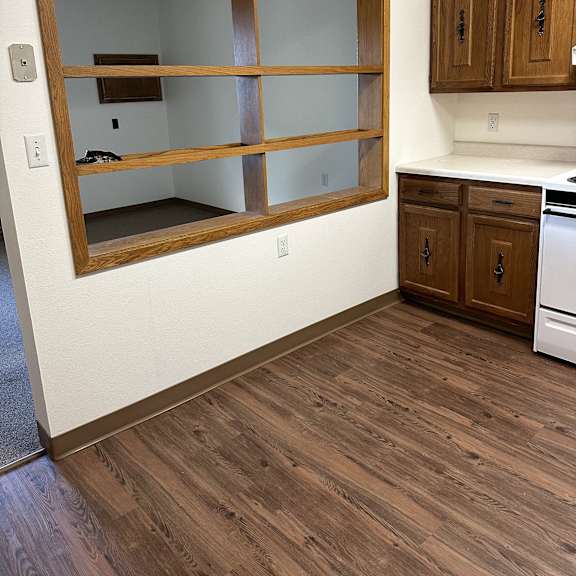 a window in the floor of a room with wooden floors and cabinets