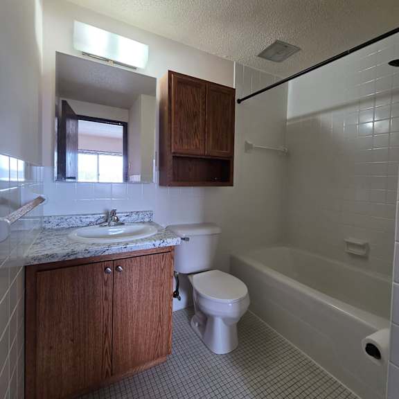 a white bathroom with a sink, toilet and bathtub.