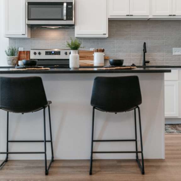 a kitchen with a black countertop and white cabinets.