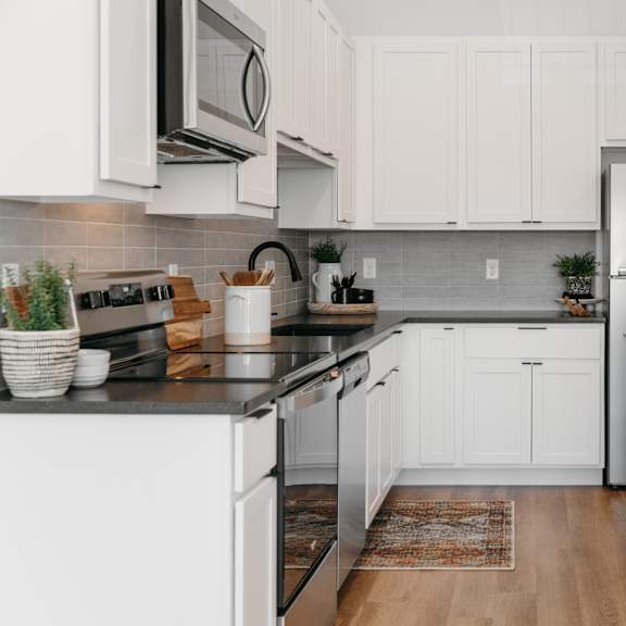 a modern kitchen with white cabinets and stainless steel appliances.