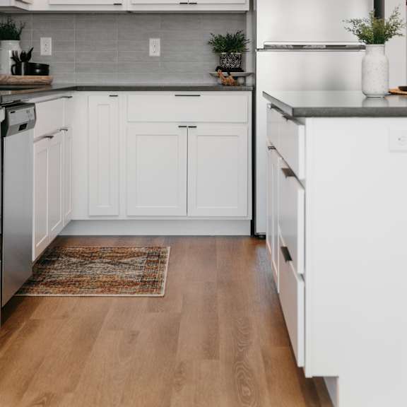 a kitchen with white cabinets and a stainless steel refrigerator.