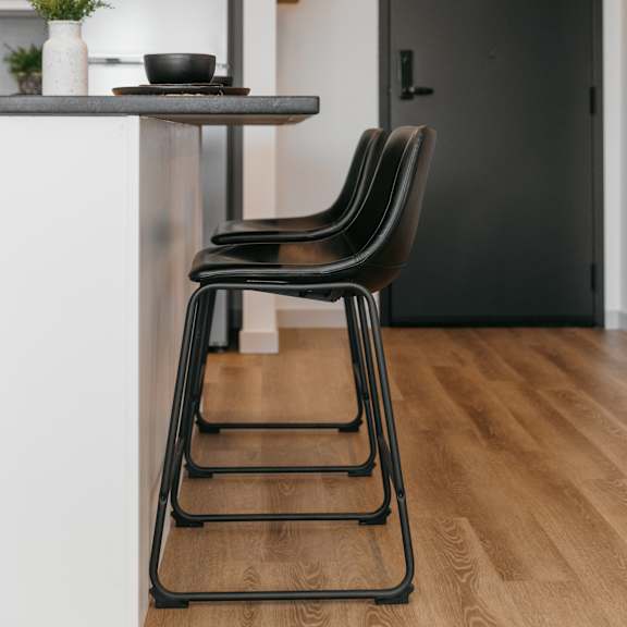 a black chair sits in front of a black door.