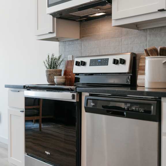 a modern kitchen with a stainless steel oven and microwave above the counter.