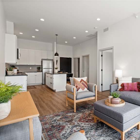 a modern living room with a grey couch and a wooden coffee table.