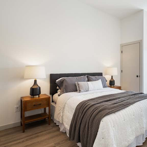 a bedroom with a large bed and a view of the city through the window.