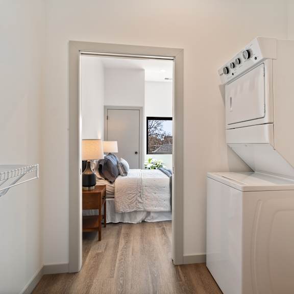 a small room with a bed and a washing machine.