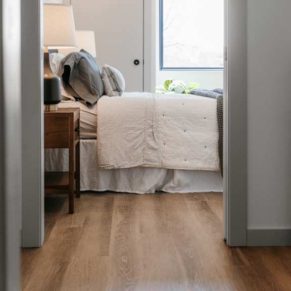a bedroom with a bed, a lamp, and a window.