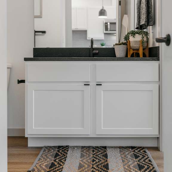 a kitchen with white cabinets and a black countertop.
