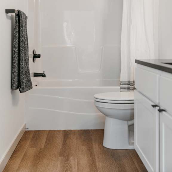 a white bathroom with a toilet, sink, and shower.
