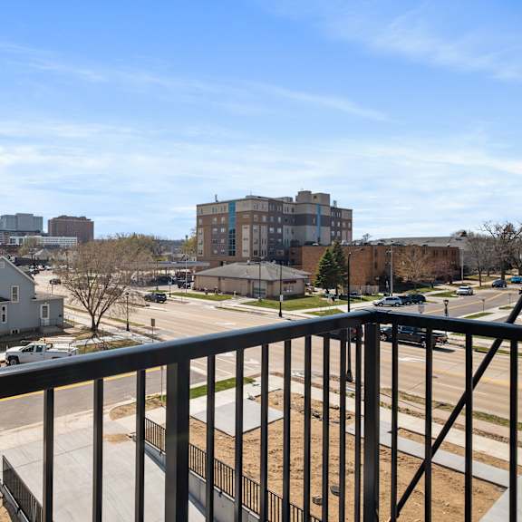 a view from a balcony overlooking a residential area with houses and apartment buildings.
