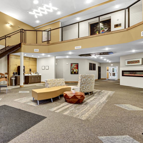 the lobby of a building with a staircase and couches