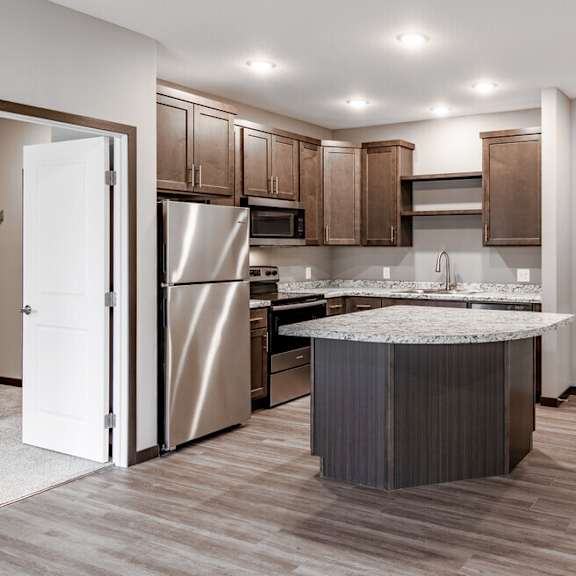 a kitchen with stainless steel appliances and a marble counter top