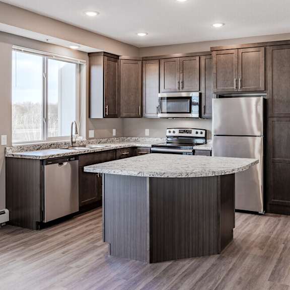 a kitchen with stainless steel appliances and a marble counter top