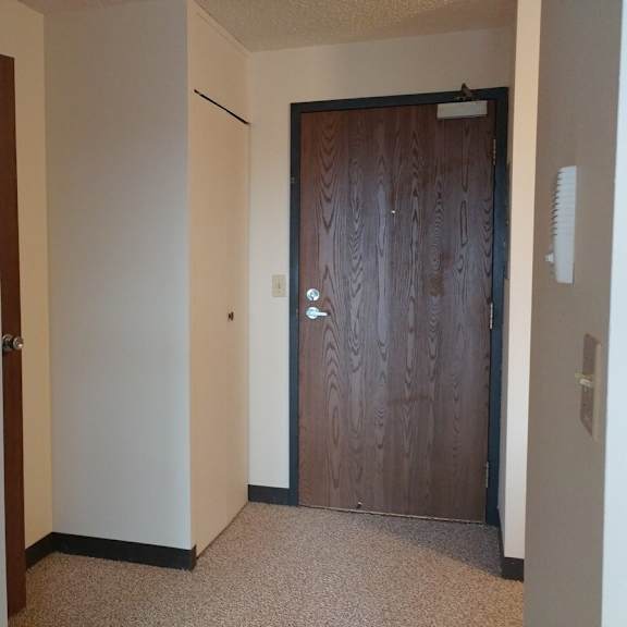 a hallway with a brown door and a white door.