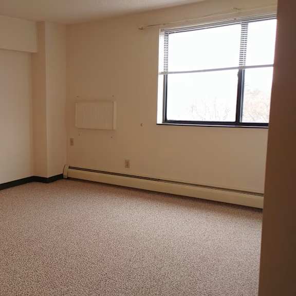 a room with a carpeted floor and a window.