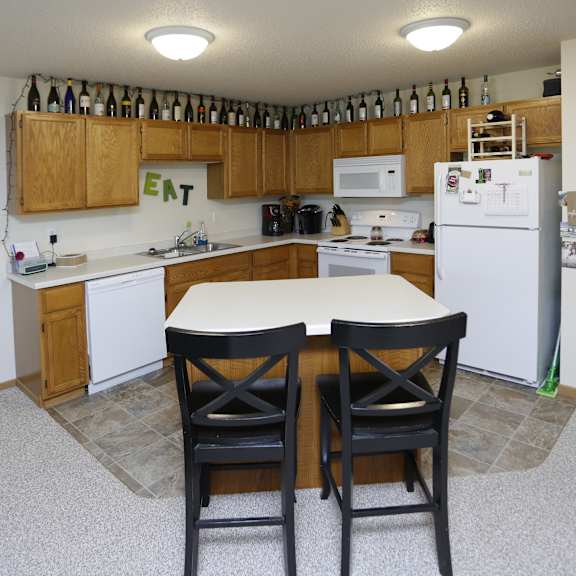 a kitchen with a table and chairs in front of it.