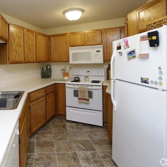a kitchen with a white fridge and white oven.