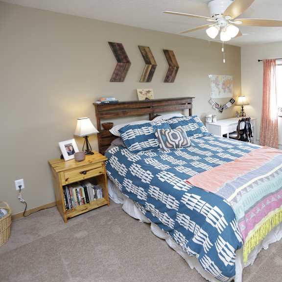 a bedroom with a bed, nightstand, and window.