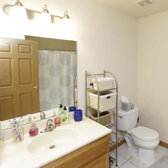 a bathroom with a toilet, sink, and mirror.