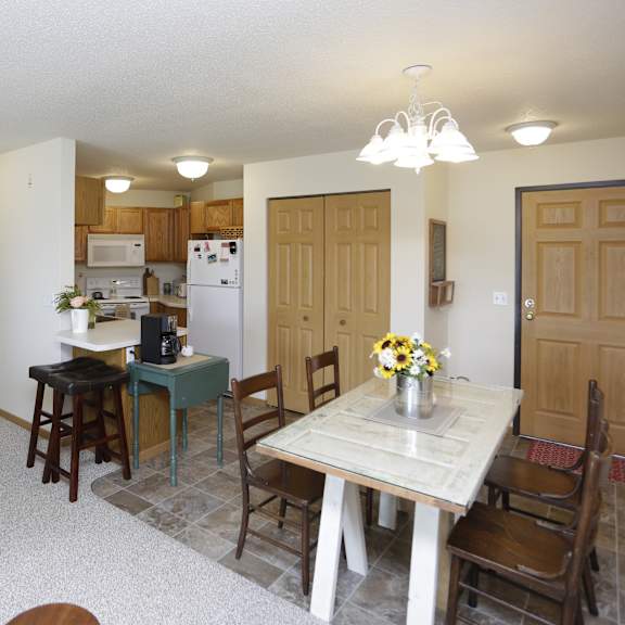 a kitchen with a table and chairs in the foreground and a couch in the background.