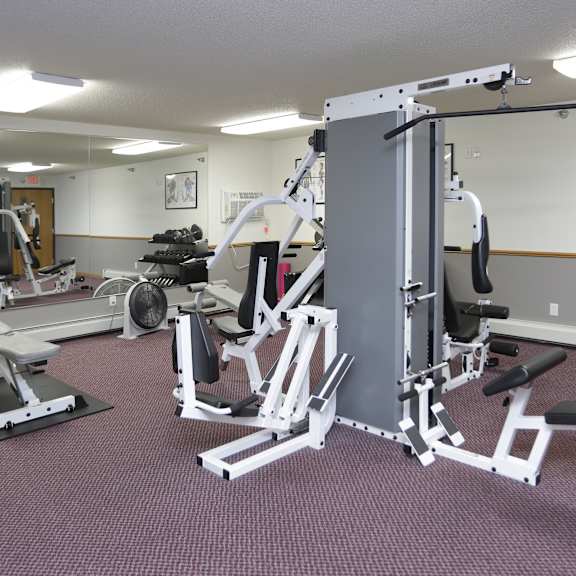 a gym with a variety of equipment including a leg press machine.