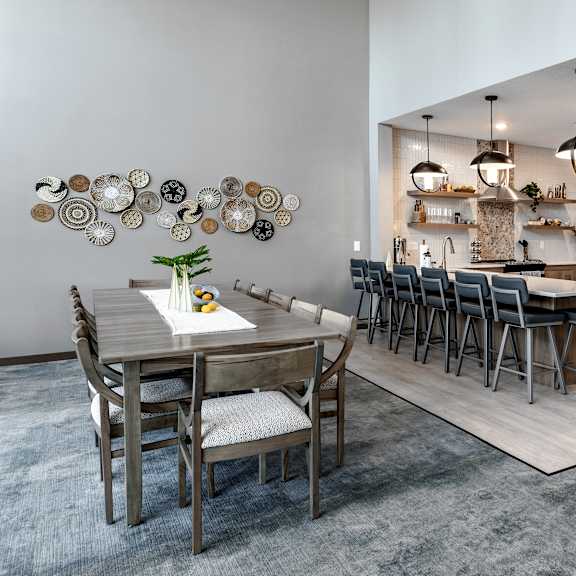 a clubhouse kitchen with a dining table and chairs.