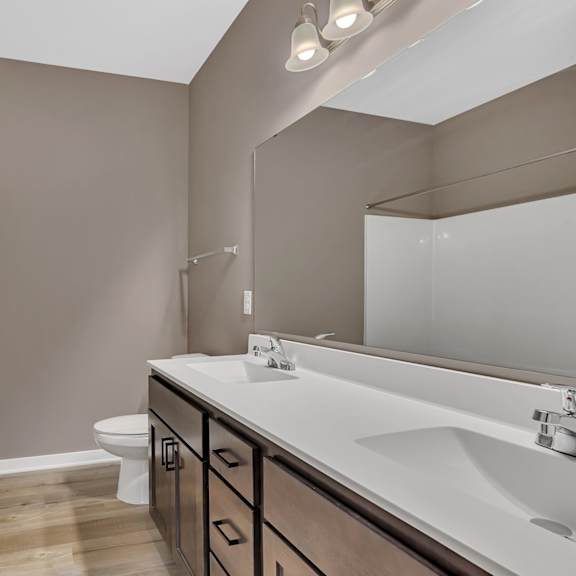 a bathroom with a white sink, a white toilet, and a white door.