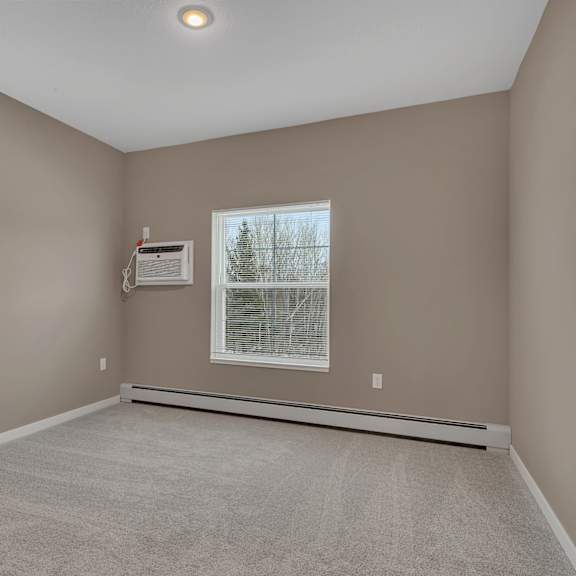 a room with a window and a carpeted floor.