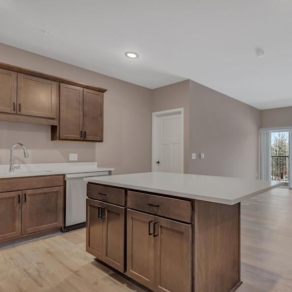 a kitchen with wooden cabinets and a white countertop.