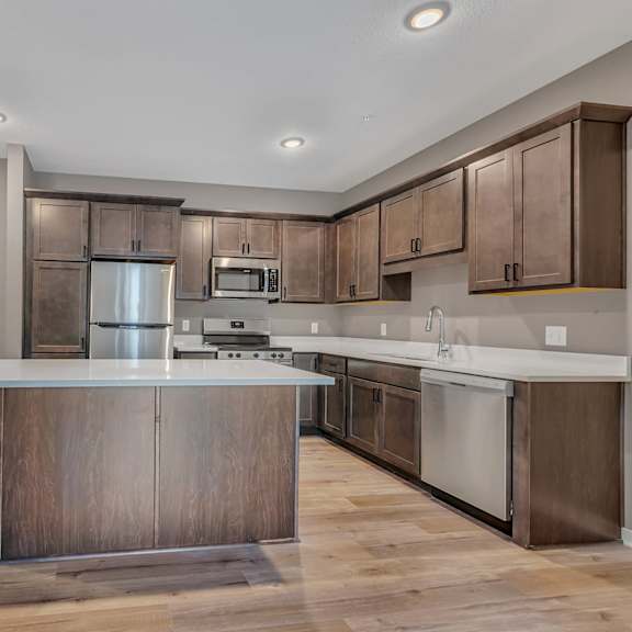 a modern kitchen with wooden cabinets and a central island.