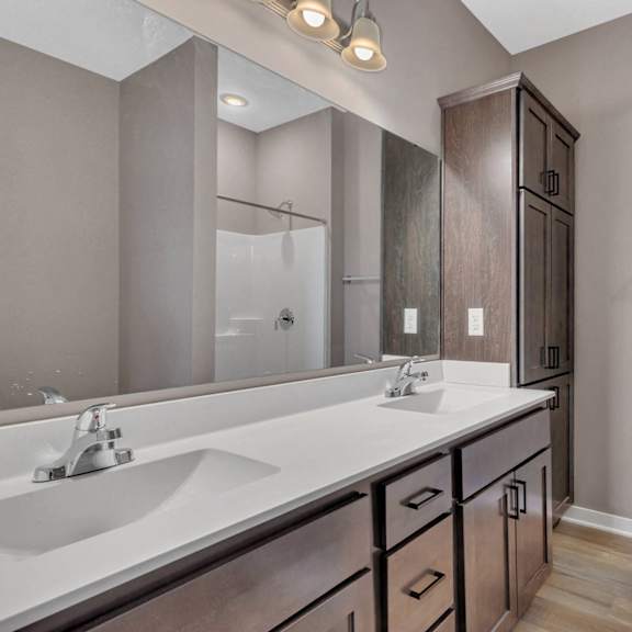 a bathroom with a double sink vanity and a large mirror.