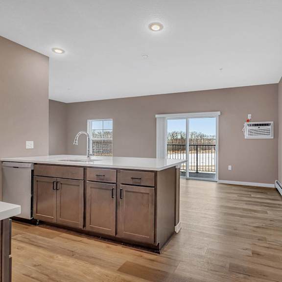 a kitchen with wooden floors and a white counter.