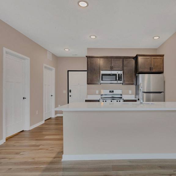 a kitchen with a white counter and brown cabinets.