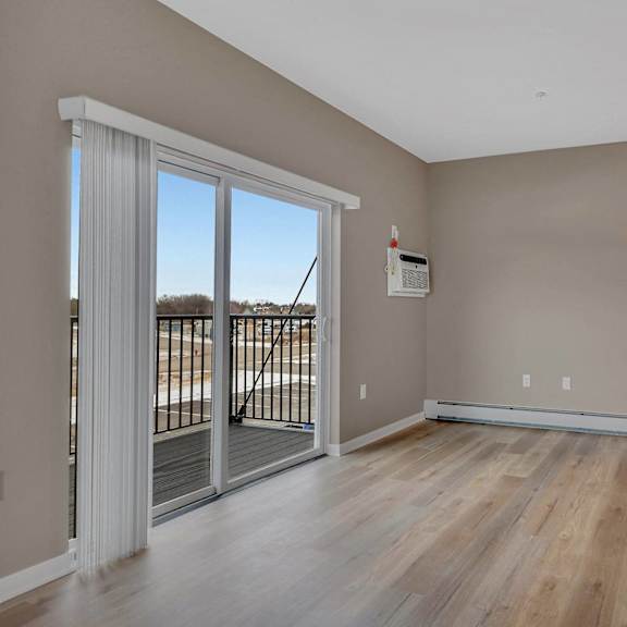 a room with a sliding glass door leading to a balcony.
