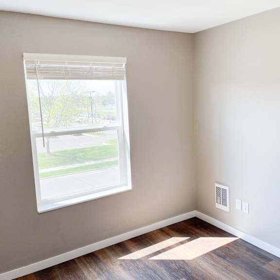 a room with a window and a wooden floor.