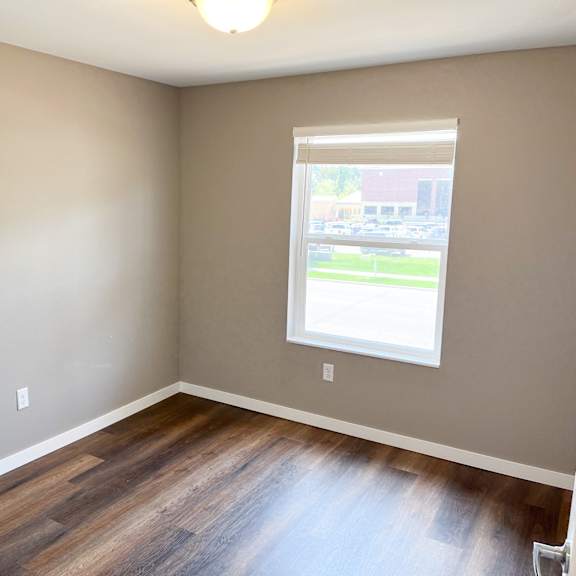 a room with a window and wooden floors.