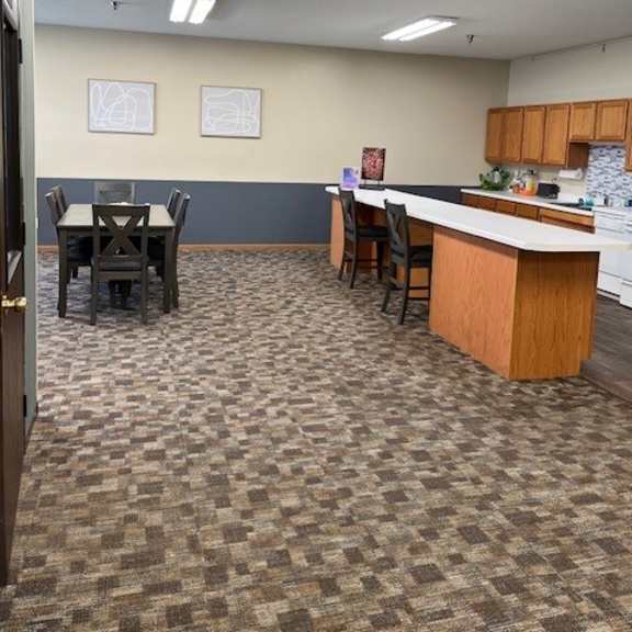 an empty room with a kitchen and a table