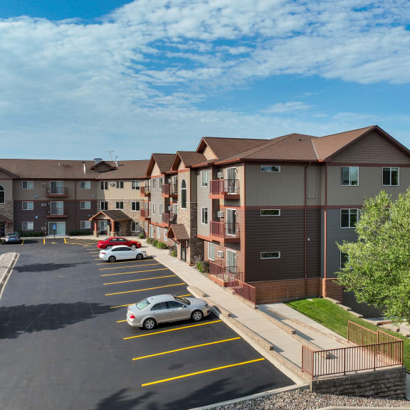 an aerial view of an apartment complex with cars in a parking lot