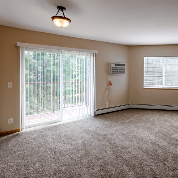 an empty living room with a fireplace and a window