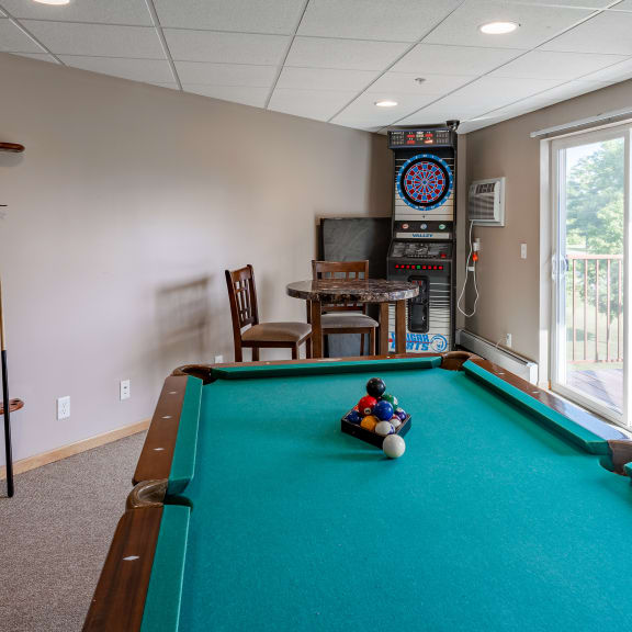 a game room with a pool table and a child playing on a