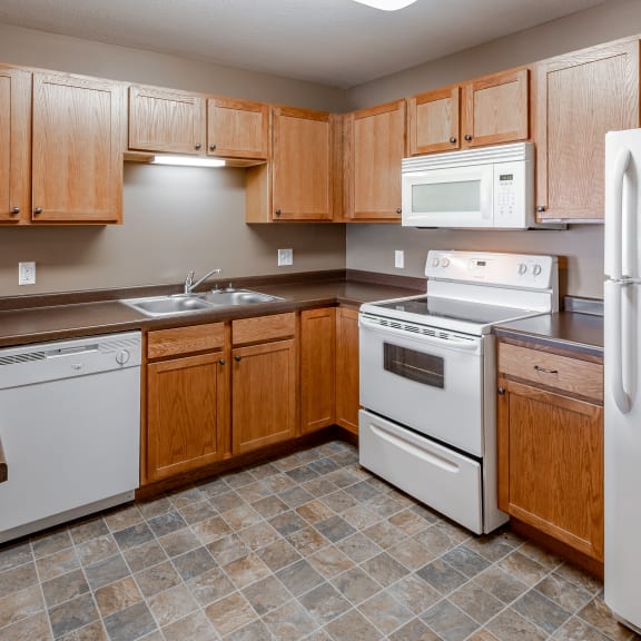 a kitchen with white appliances and wooden cabinets