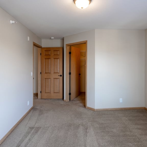 a living room with carpet and a door into a bedroom