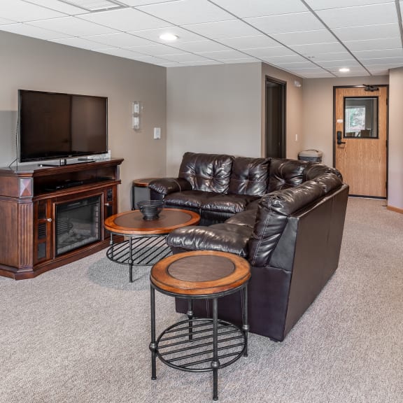 a living room with a leather couch and a television